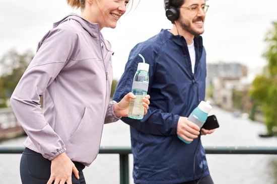 Femme en veste violette et homme en veste bleue courant avec une bouteille bleue et une autre turquoise.