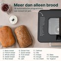 Broodbakmachine met twee broden, jam en yoghurt.