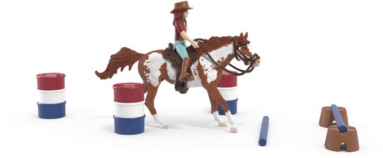 Bruin-witte paardenfiguur met ruiter in westernoutfit, omringd door barrels en palen.