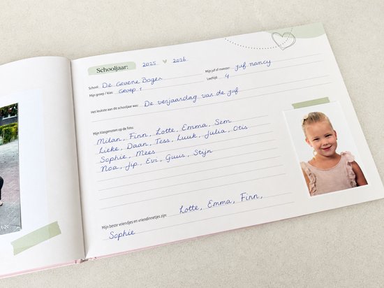 Een meisje met blonde krullen, een roze jurk en grote oorbellen zit op een houten kistje. Tekst: 'School: De Groene Bogen, Mijn groep / klas: Groep 1'.