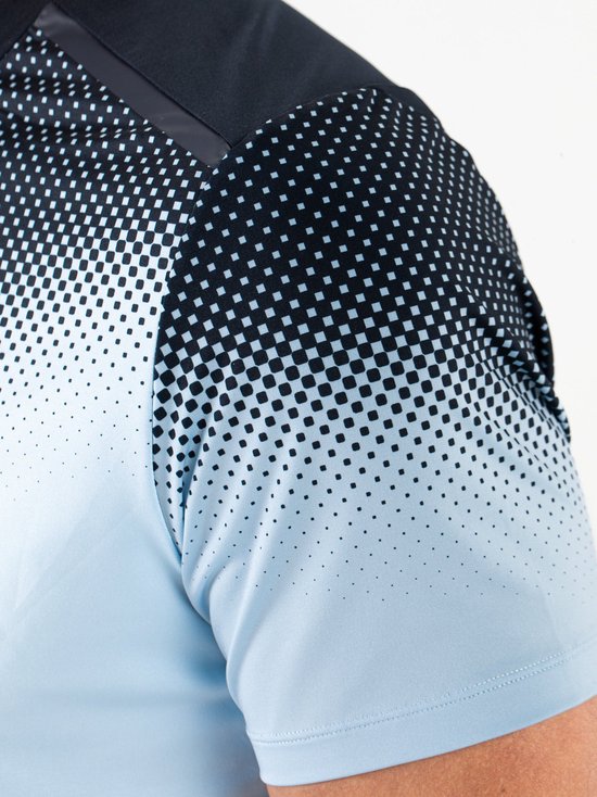 Detail van een lichtblauw tennisshirt met donkerblauwe stippen en vierkantjes die vervagen.