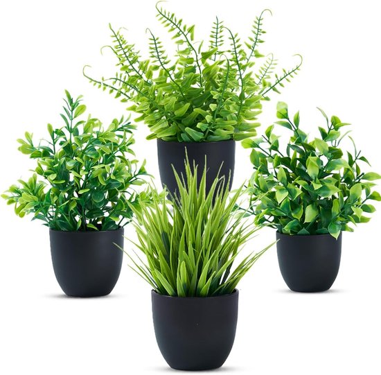 Groupe de quatre plantes artificielles vertes en pots noirs, sur fond blanc.