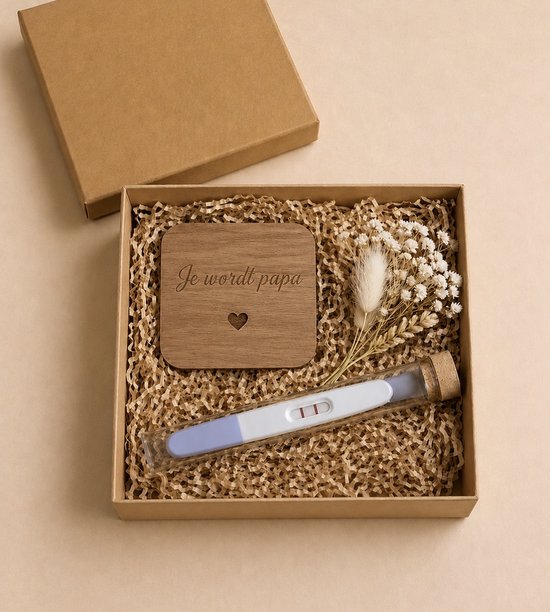 Boîte cadeau avec 'Tu deviens papa' gravé sur le couvercle en bois, test de grossesse et fleurs séchées.