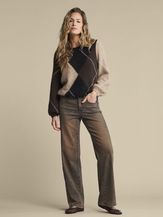 Model draagt een bruine trui met argyle patroon in zwart, bruin en beige. Licht pofmouwen.