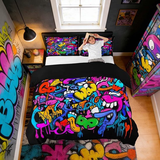 Kind leest een boek op een bed met felgekleurd graffitidekbed en tekst 'WOW' in het patroon.