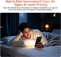 Man ligt in bed en kijkt op een smartphone in een verduisterde kamer.