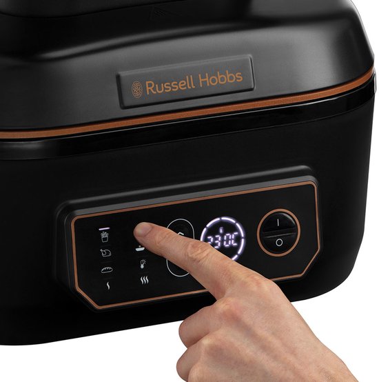 Vinger drukt op het bedieningspaneel van de Russell Hobbs airfryer met digitale temperatuurweergave.