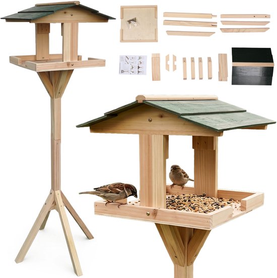 Houten vogelhuis op paal met groen dak, met twee mussen die eten en losse onderdelen.