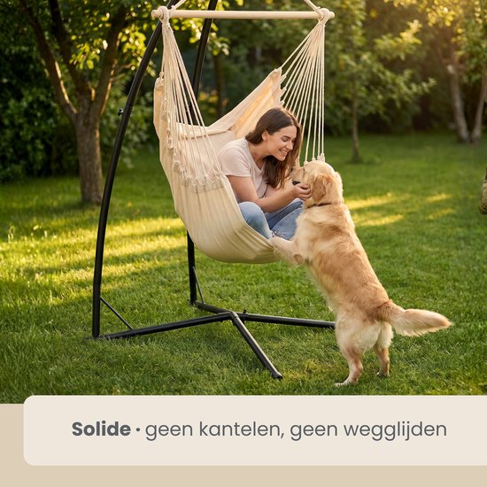 Vrouw met hond in crème hangmat in de tuin, solide zonder kantelen of wegglijden.