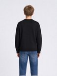 Achterkant van een zwarte fijngebreide trui op een jongen met blauwe jeans.