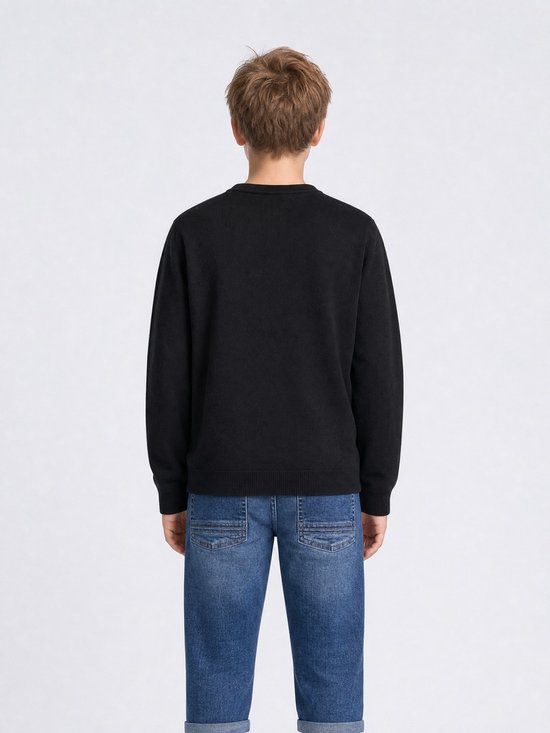 Achterkant van een zwarte fijngebreide trui op een jongen met blauwe jeans.