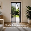 Zwarte magnetische hor geopend in een deuropening, met uitzicht op een groene tuin.