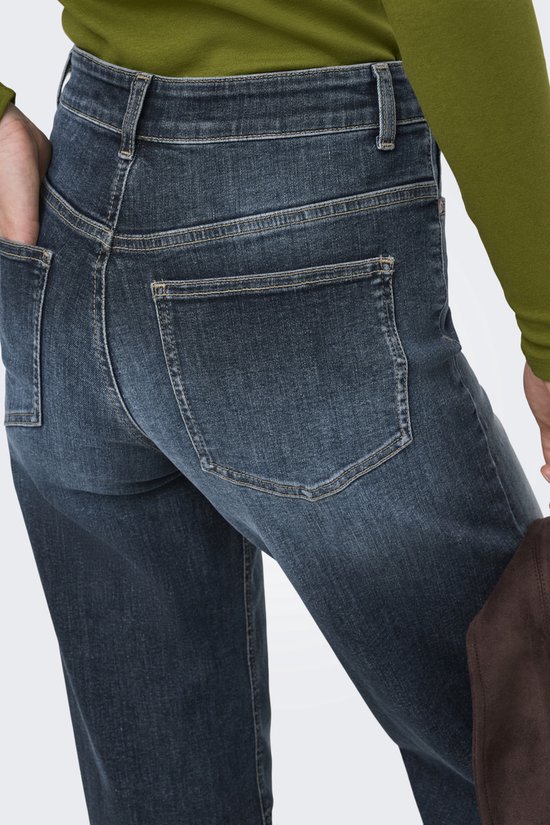 Close-up van de achterkant van een spijkerbroek in donkerblauw denim met wassing. Twee zakken aan de achterkant.