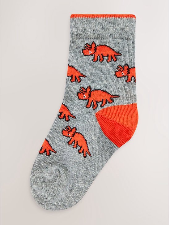 Grijze sokken met een print van oranje dinosaurussen en oranje tenen.