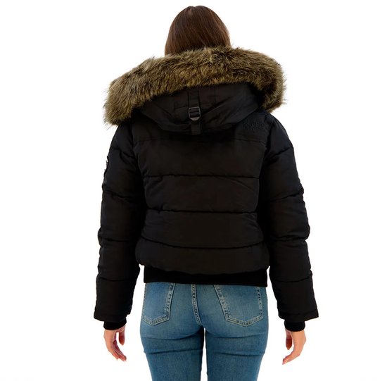 Achterkant van een zwarte Superdry bomberjack met capuchon en bruine bontkraag, op een model met spijkerbroek.