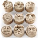 Neuf formes de sable avec des visages: une lune, un hibou, deux personnes, un extraterrestre, un chat et un homme avec une moustache.