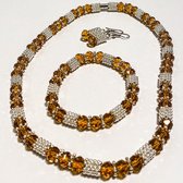 Gouden sieradenset met kristallen , set van drie. Ketting, armband en oorbellen
