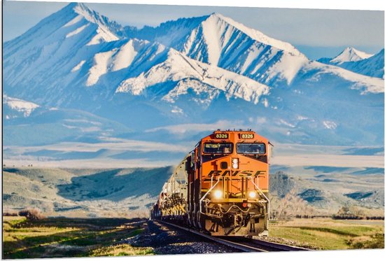Dibond - Oranje Trein met Besneeuwde Bergen op de Achtergrond - 120x80cm Foto op Aluminium (Wanddecoratie van metaal)