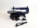 Blauwe FERM figuurzaagmachine met voetpedaal en stekker, op witte achtergrond.