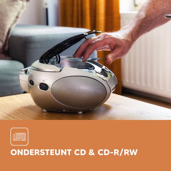 Een zilverkleurige draagbare radio-cd-speler met een opengeklapte deksel, waar een hand een cd in plaatst. Compact Disc Digital Audio.