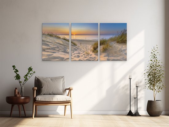 Triptyque du coucher de soleil sur la mer, photographié depuis un chemin de dune. Accroché au-dessus d'un fauteuil.