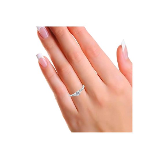 Een hand met nette nagels draagt een zilverkleurige ring met drie zirkonia's.
