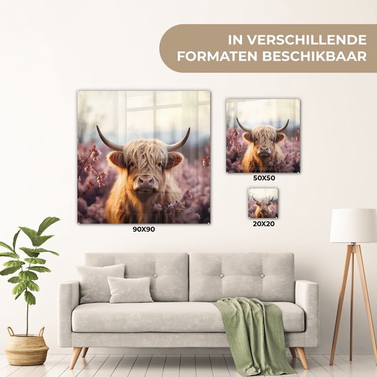 Glazen schilderij van een Schotse hooglander, omringd door roze bloesems, getoond in verschillende formaten boven een bank.