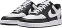Zwarte en witte Nike sneakers met witte veters. De zijkant heeft een witte swoosh.