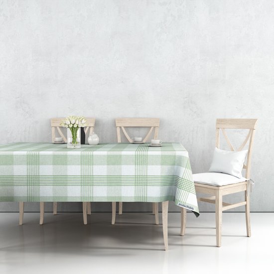 Eetkamer met een tafel gedekt met een groen en wit geruit tafelzeil, met houten stoelen en een vaas tulpen.