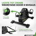 Zwarte hometrainer met acht weerstandsniveaus, instelbaar met een groene draaiknop. Inclusief riemen om aan stoelen te bevestigen.