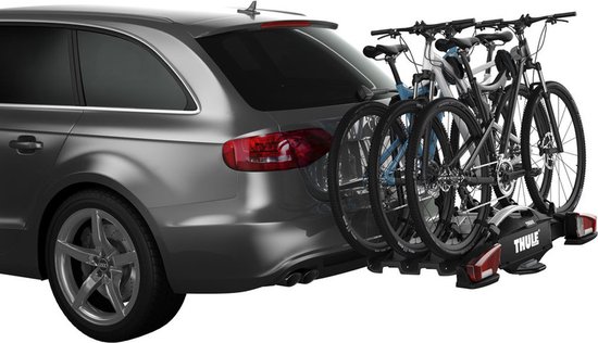 Een grijze stationwagon met de Thule VeloCompact fietsendrager, met 3 fietsen, achteraan gemonteerd.