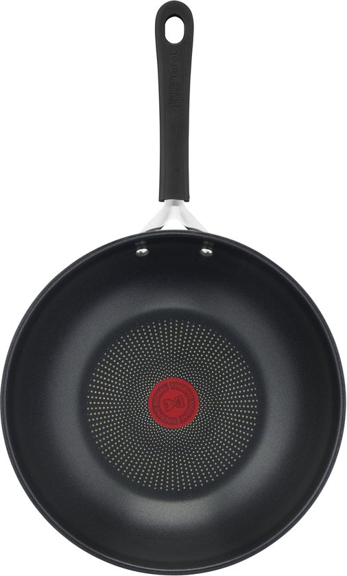Zwarte wokpan met een zwart handvat en een rood Tefal Thermo-Spot in het midden.