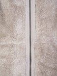 Close-up van de beige fleece stof met middenrits van een bodywarmer.