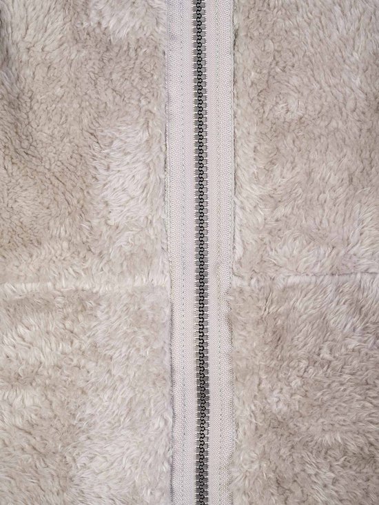 Close-up van de beige fleece stof met middenrits van een bodywarmer.