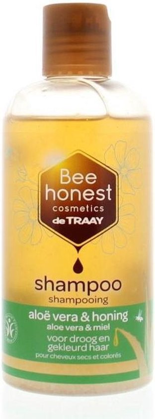 Transparante fles shampoo met bruine dop. Shampoo is goudkleurig. Tekst: shampoo aloë vera & honing.