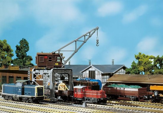 Grue stationnaire au-dessus d'un train avec locomotives et wagons de marchandises.