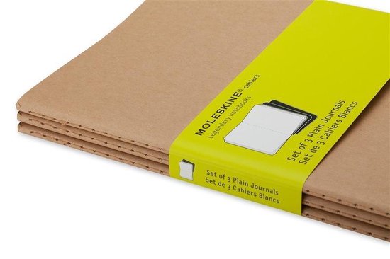 Detail van een stapel bruine Moleskine cahiers met een gele band met 'Set of 3 Plain Journals'.
