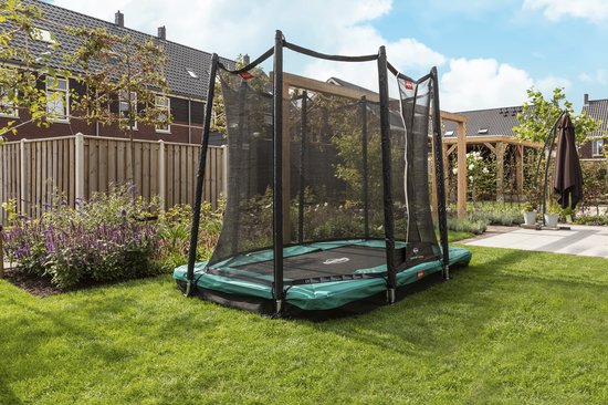 BERG trampoline met groen beschermkussen in een zonnige achtertuin.