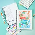 Een blanco Ohuhu marker papier blok naast een blok met een zomerse kikkerillustratie, met kleurstalen.