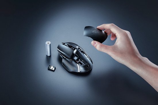 Zwarte Razer Basilisk V3 X Hyperspeed muis met afneembare dop, AA-batterij en USB-dongle op donkere achtergrond.