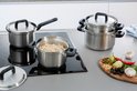 Een kookpan met pasta staat op een kookplaat naast andere pannen.