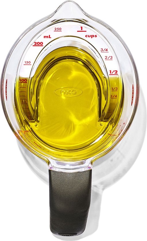 Doorzichtige maatbeker van 250 ml gevuld met olijfolie, met rode schaalverdeling, van bovenaf te lezen, met zwarte handgreep.