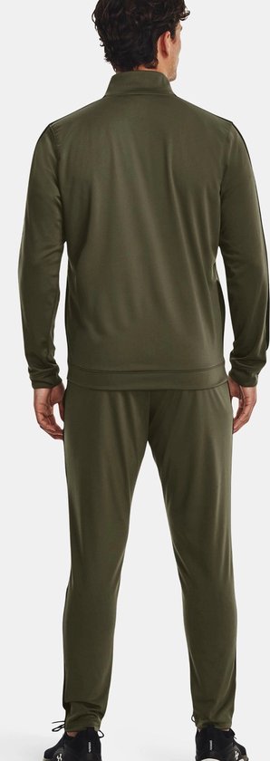 Man met donkergroen trainingspak, achterkant, met lange mouwen en broek met rechte pijpen.