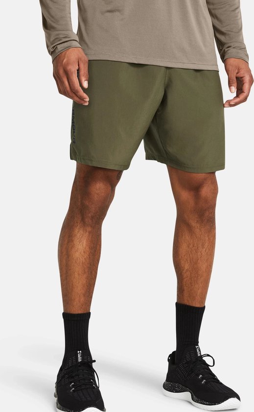 Militaire groene sportshort met elastische tailleband, zakken en zwarte schoenen.