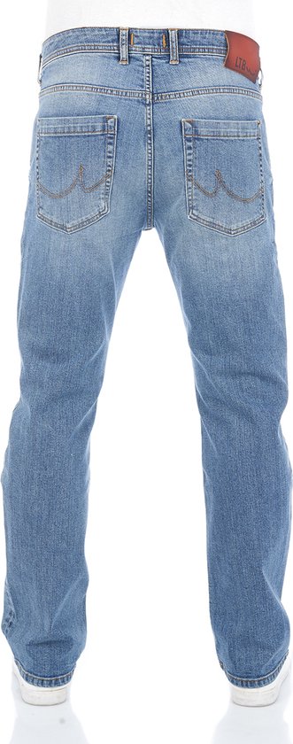 Achterkant van een man met een rechte blauwe spijkerbroek en witte sneakers.