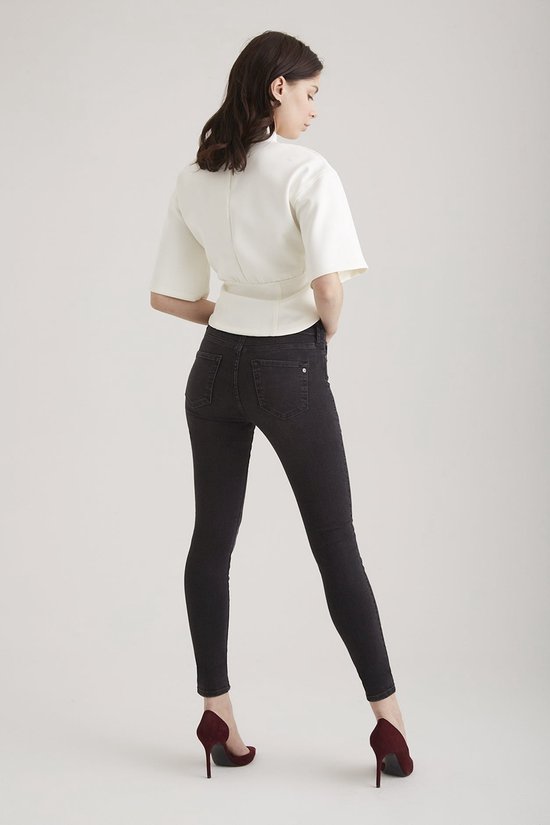 Model van achteren in zwarte Sophia skinny jeans en wit shirt.