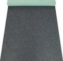 Tapis gris foncé déroulé, avec une partie du dessous vert à pois