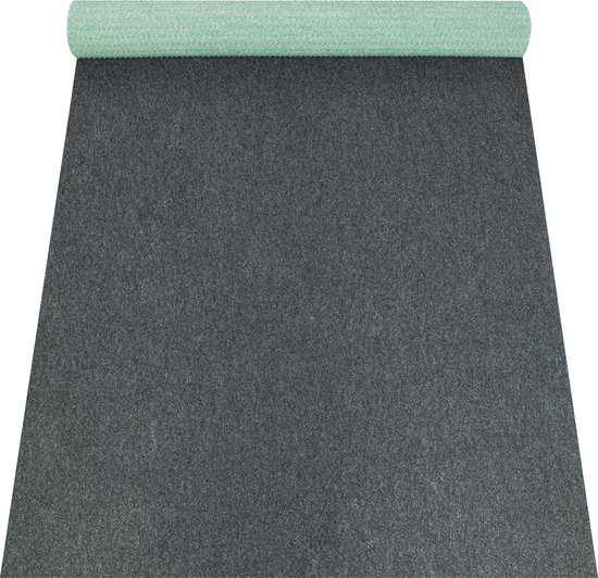 Tapis gris foncé déroulé, avec une partie du dessous vert à pois