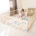 Houten babybox met ballenbak, een vrouw en kind spelen in een woonkamer.