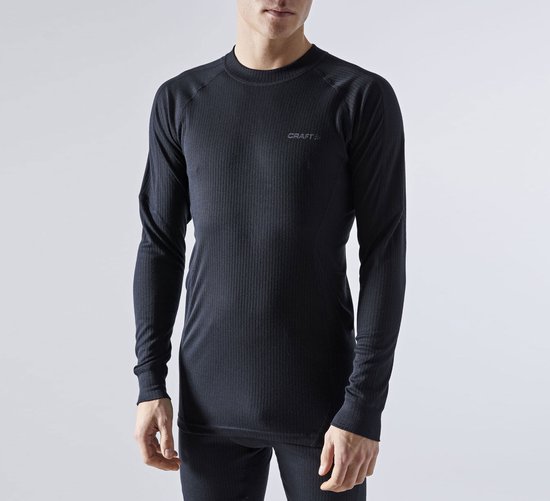 Man in zwart, nauwsluitend thermoshirt met lange mouwen, ribbelstructuur en Craft logo op de borst.